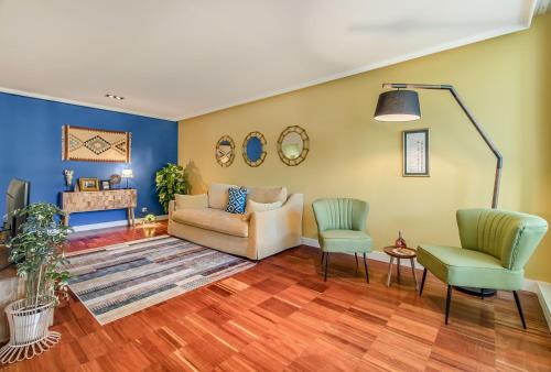 uma sala de estar com um sofá e duas cadeiras em 347 Acácias Flat em Lisboa