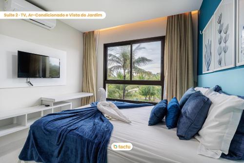 a bedroom with a bed with blue walls and a window at Apartamento gigante VG Sun Cumbuco por Tactu in Cumbuco