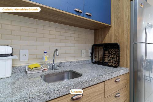 a kitchen counter with a sink and a refrigerator at Apartamento gigante VG Sun Cumbuco por Tactu in Cumbuco