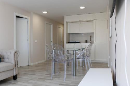 a dining room with a glass table and chairs at Sunset 4C in Santa Pola