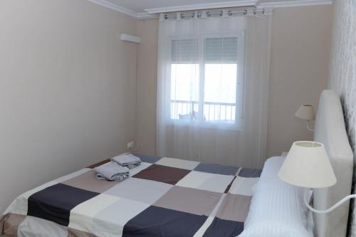 a bedroom with a bed and a window and a lamp at Sunset 4C in Santa Pola