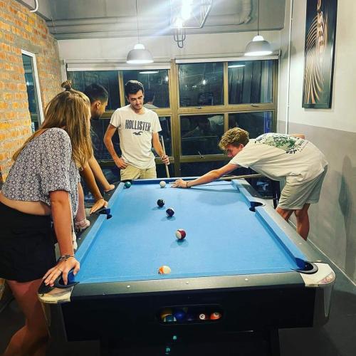 a group of people standing around a pool table at BRICKS Cameron Hostel in Tanah Rata