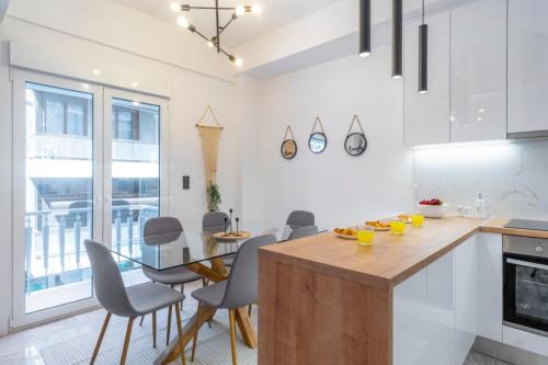 een keuken met een tafel en stoelen en een eetkamer bij Modern flat in Kolonaki in Athene