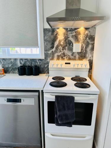 a kitchen with a white stove with a towel on it at Spacious 4 bedroom House in Manukau in Auckland