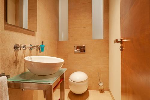 a bathroom with a bowl sink and a toilet at STING Boutique Apartments in Ostrava