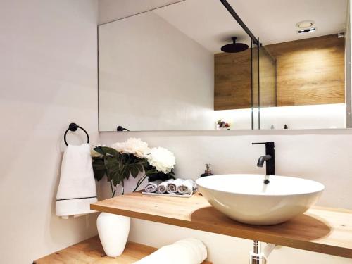 a bathroom with a white bowl sink on a wooden counter at Increíble apartamento de lujo en Terrassa in Terrassa