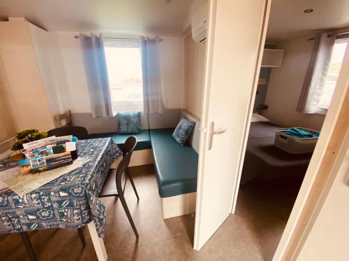 a small room with a table and a room with a bed at Mobilhome P27 6 personnes climatisé in Le Portel