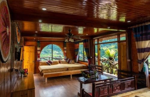 a bedroom with a bed in a room with windows at Muong Hoa River View Homestay in Sa Pa
