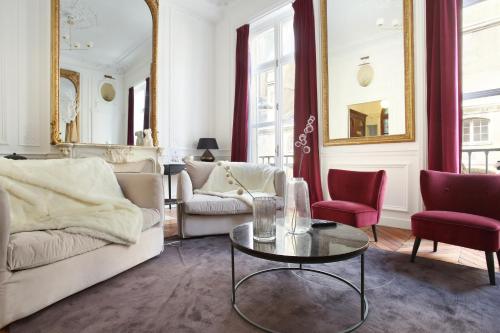 un salon avec un canapé et une table dans l'établissement Residense Louvre Museum by Studio prestige, à Paris