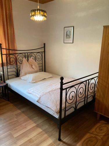 a bedroom with a black bed with white sheets and pillows at Moserwirt Pension in Sankt Veit an der Glan