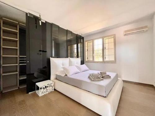 a white bedroom with a large bed and a window at Villa Rachele con piscina in Balestrate