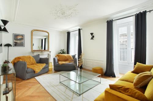 un salon avec un canapé et une table en verre dans l'établissement Residense Louvre Museum by Studio prestige, à Paris