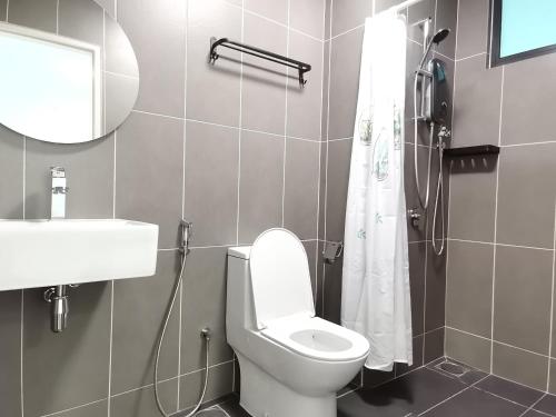La salle de bains est pourvue de toilettes, d'un lavabo et d'un miroir. dans l'établissement Greenfield Residence Bandar Sunway Petaling Jaya, à Petaling Jaya