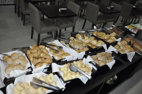 a table with a bunch of different types of food at AlphaPark Hotel in Goiânia