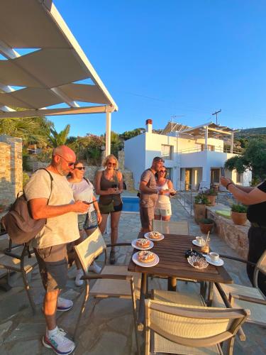 a group of people standing around a table on a patio at Mourtzanakis Residence - Traditional Eco Hotel in Achlada in Achlada