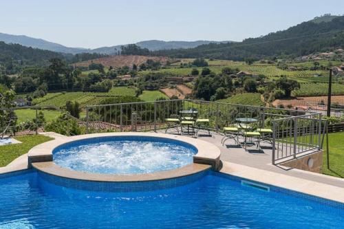 a swimming pool with a view of a vineyard at Fernandes Guest House Sunshine Studio in Ponte de Lima