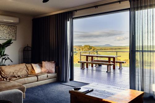 a living room with a couch and a large sliding glass door at Wamoon Retreat - Luxe House in Yanakie