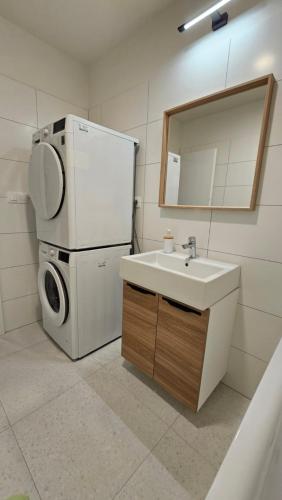 eine Küche mit einer Spüle, einem Kühlschrank und einer Waschmaschine in der Unterkunft 2 room Apartment with terrace, new building, 2BK in Bratislava