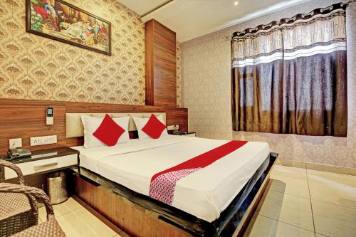 1 dormitorio con cama, escritorio y ventana en OYO Flagship 81231 Hotel Seven en Ludhiana