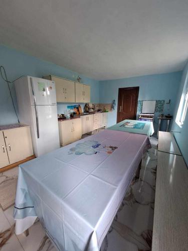 a kitchen with a large bed in a room with a refrigerator at Guesthouse Luka in Martvili