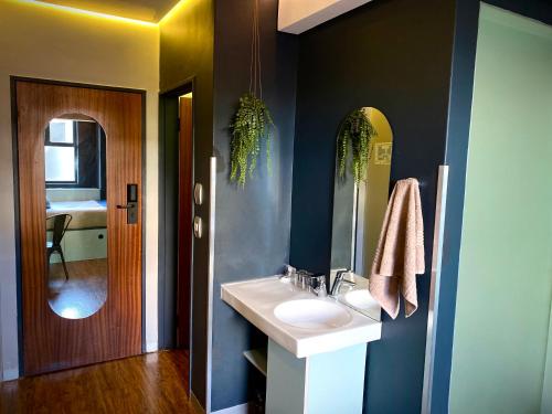 bagno con lavandino e specchio di Bannister Hotel a Johannesburg