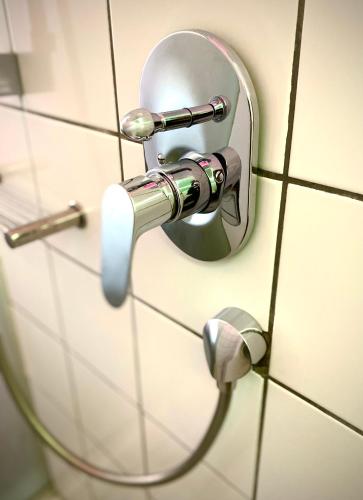 a bathroom door with a mirror on a tiled wall at Bannister Hotel in Johannesburg
