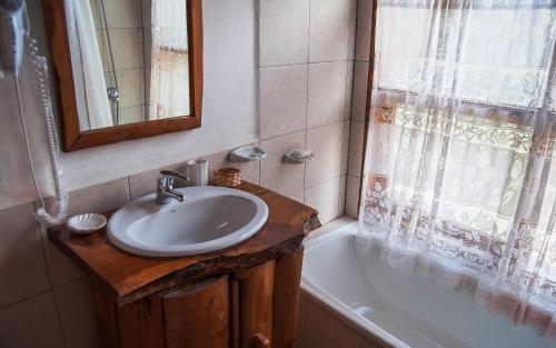uma casa de banho com um lavatório e uma banheira em Cabañas Lelikelen em Villa La Angostura