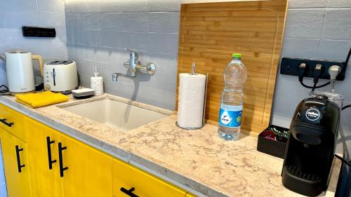 a kitchen counter with a sink and a bottle of water at GW317 Gugel Waves Amazing Seaview Pool Apartments in Nahariyya