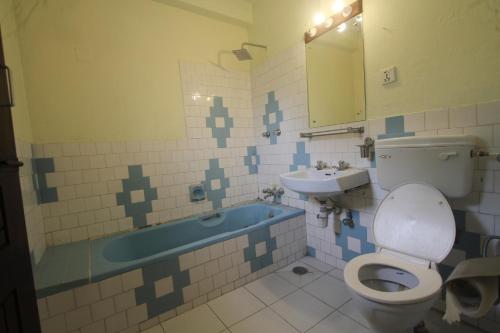 a bathroom with a toilet and a sink at Hotel Bedrock in Pokhara