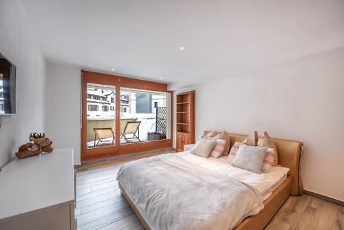 um quarto com uma cama grande e uma varanda em Esclusivo bilocale centralissimo em St. Moritz