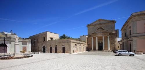 a building with a car parked in the middle of a street at B&B Incanto Salento in Ugento