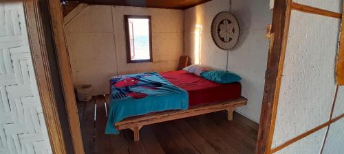 een kleine slaapkamer met een bed in een kleine kamer bij Ekas beach floating room and restaurant in Ekas