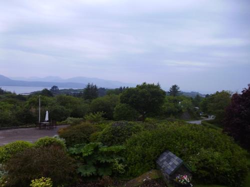 a park with a bench and a view of the water at Hillside Haven in Tahilla