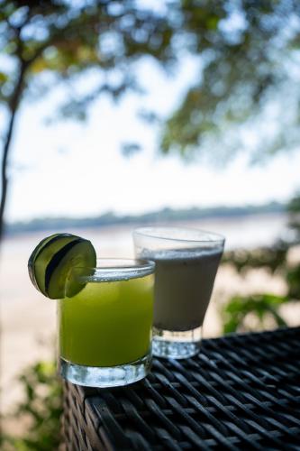 a glass of green drink with a lime on a table at Ecolucerna Lodge Tambopata in Puerto Maldonado