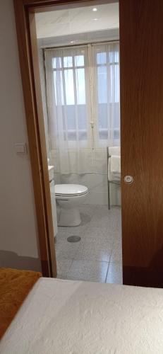 a bedroom with a bathroom with a toilet and a window at Hotel Paulista in Porto