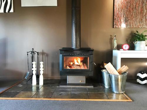 a fireplace in a living room with a stove at Prom Beach House in Sandy Point