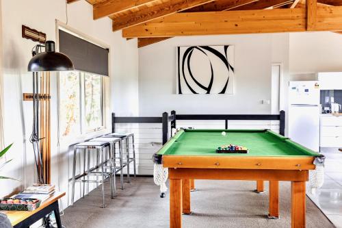 a pool table in a living room with a bill at Prom Beach House in Sandy Point