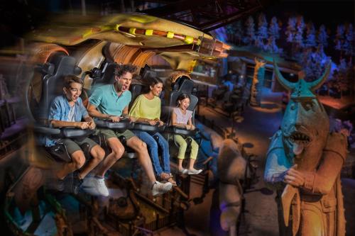 a group of people sitting on a carousel at Lapita, Dubai Parks and Resorts, Autograph Collection in Dubai