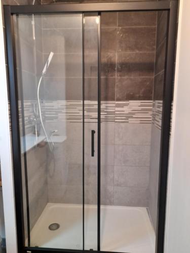 y baño con ducha y puerta de cristal. en La petite Pèlerine en Narbona
