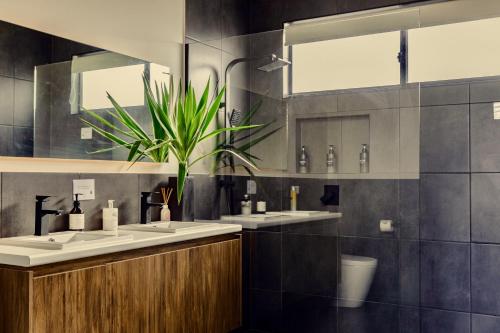 een badkamer met 3 wastafels en een potplant bij Wamoon Retreat Apartment Luxury Gateway to Wilsons Prom in Yanakie