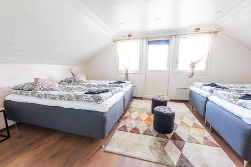 a room with two beds in a attic at Hommala Riverside Lodge with Terrace, Sauna & Auroras near Rovaniemi in Raiskio
