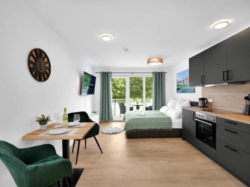 a kitchen and living room with a bed and a table at INhome Studio Apartment - Küche - Parken - TV in Schwäbisch Hall