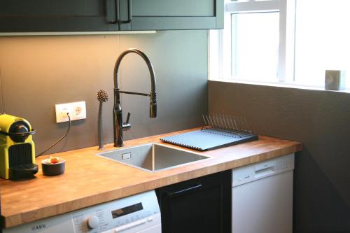 a kitchen with a sink and a counter with a sink at Spacious & refurbished 1 bedroom apartment in suburban Reykjavik in Garðabær