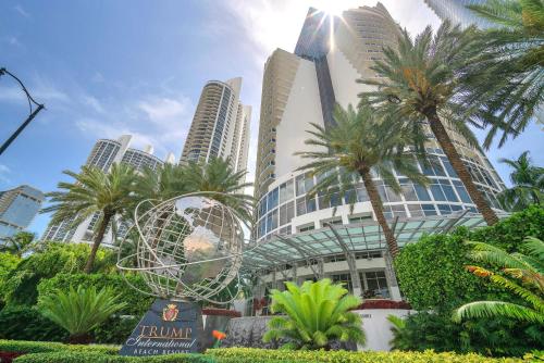 un gruppo di palme davanti a un edificio di TRUMP INTL 2 BEDROOM APARTMENT 1600 Sqf OCEAN FRONT a Miami Beach