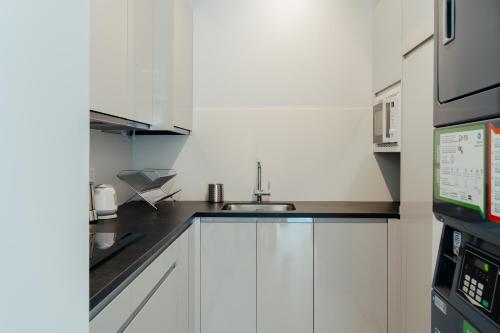 a kitchen with white cabinets and a sink at HOSTEL ALEA in León