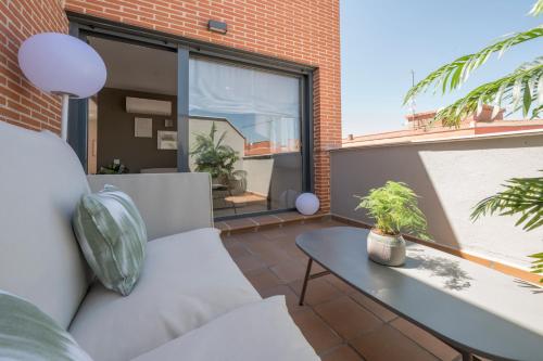 Miosotis Suites في مدريد: شرفة مع أريكة وطاولة