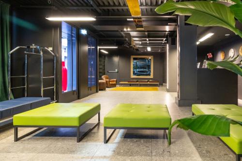a lobby with green benches and a waiting room at Smart Hotel Central in Milan