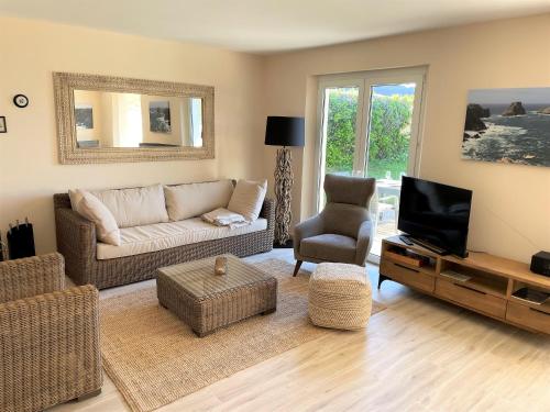 un salon avec un canapé et une télévision dans l'établissement Helles Ferienhaus mit Meerblick, à Camaret-sur-Mer