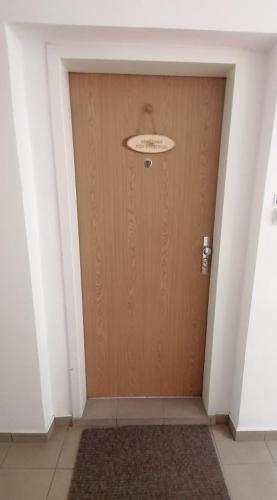 a wooden door in a hallway with a rug at Pod střechou in Svoboda nad Úpou
