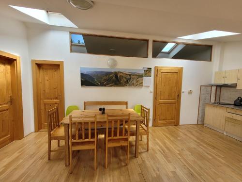 a dining room with a wooden table and chairs at Pod střechou in Svoboda nad Úpou